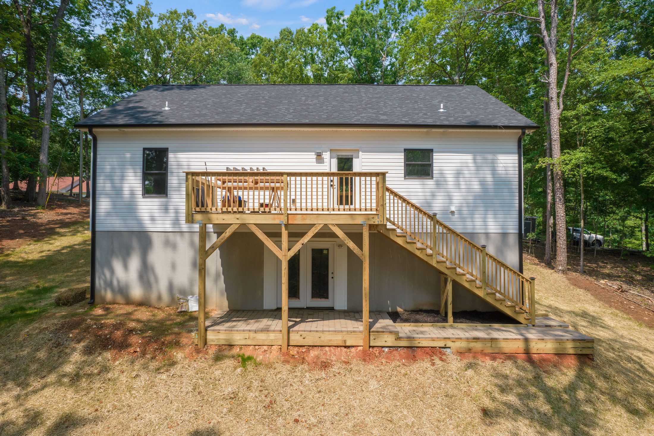 Rear of the Lakeside Getaway home with a new wood deck and stairs