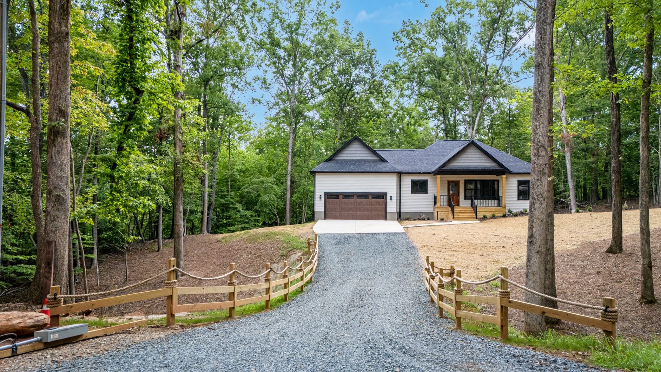Gravel driveway with a split-rail fence leading to the Raven's Ridge custom home in Mt. Gilead, NC