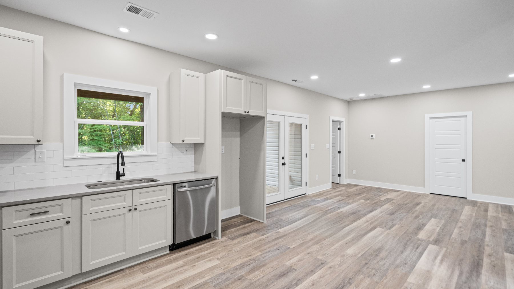 Open kitchen with gray shaker cabinets and stainless appliances at Raven's Ridge
