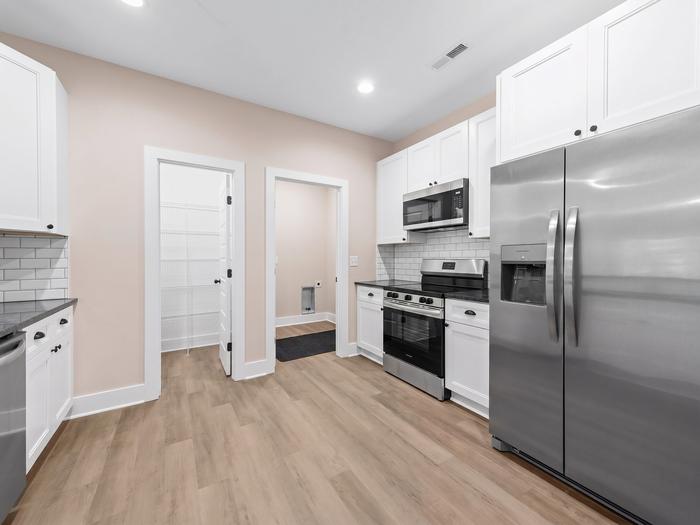Kitchen with white cabinets, stainless appliances and a walk-in pantry