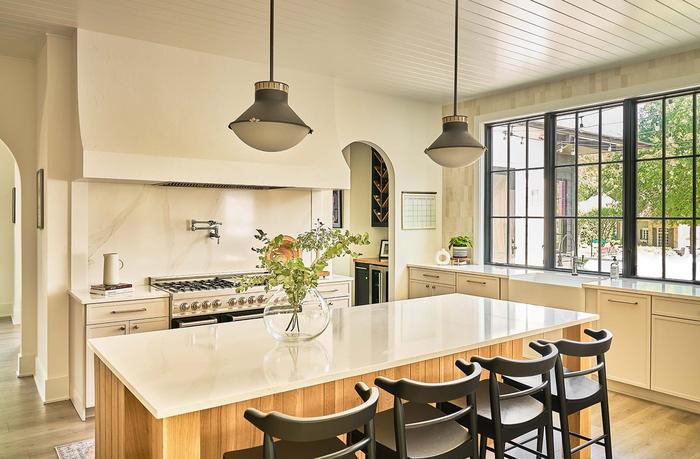 Kitchen with a white oak island, pendant lights and plaster range hood