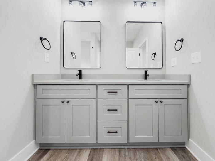 Double vanity with black-framed mirrors and fixtures at Raven's Ridge