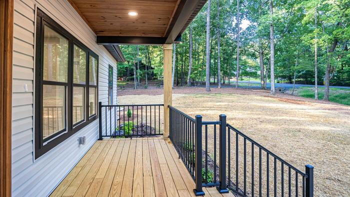 Covered side porch with black metal railings at Raven's Ridge
