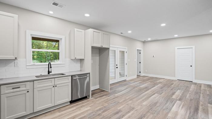 Open kitchen with gray shaker cabinets and stainless appliances at Raven's Ridge